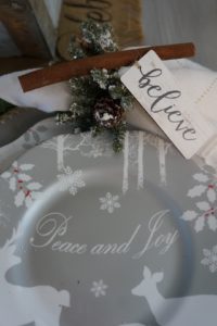 Christmas dining room table setting silver plates layered with chargers