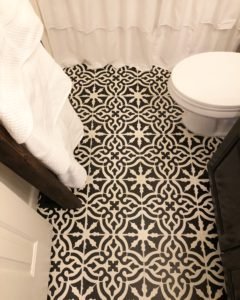 Stenciled cermaic tiles in bathroom, done in Blackberry House paint- black and white tile floors