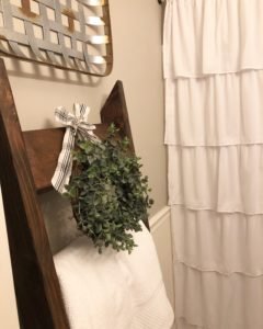 Budget bathroom makeover for the $100 room challenge. Ladder with towels and eucalyptus wreath
