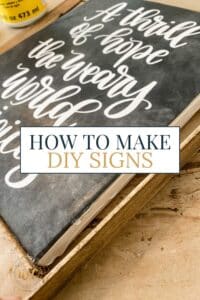 Close-up of a DIY wooden sign featuring white script text on a black background with a rustic wood frame, overlaid with text that reads “How to Make DIY Signs.”