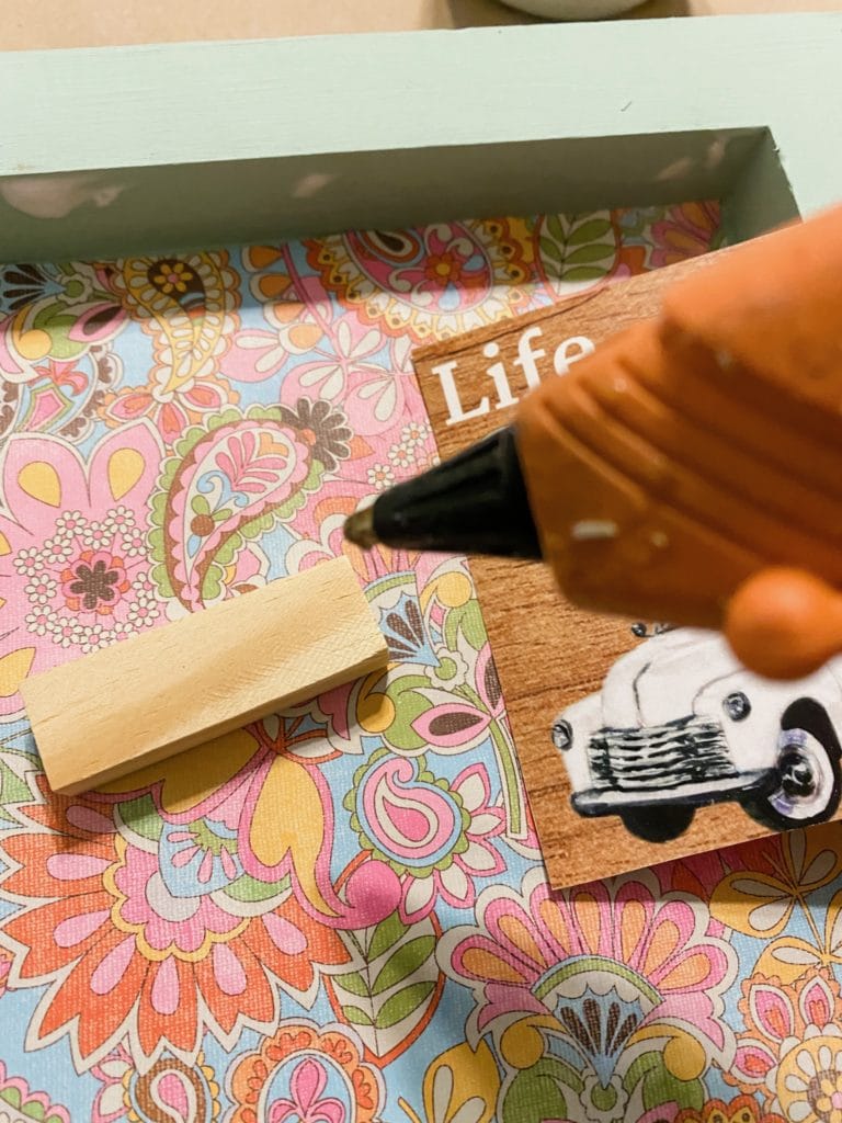 I had painted my craft sticks to match the wood, so I attached those at the top and bottom of the printable with hot glue and then added a little half wood bead for fun too!