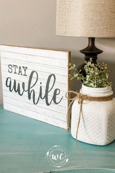 Stay Awhile sign on end table with lamp