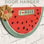 Summer watermelon painted sign with burlap flower hanging on brick wall