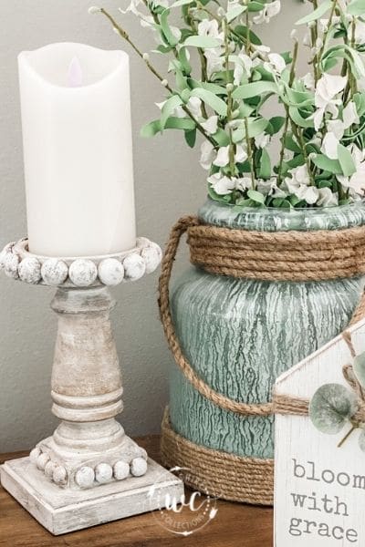 candlestick holder with green vase and greenery